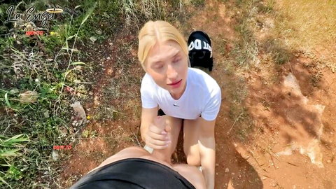 Lia Engel blonde kneeling outdoors in white Nike top and cap, teasing solo play