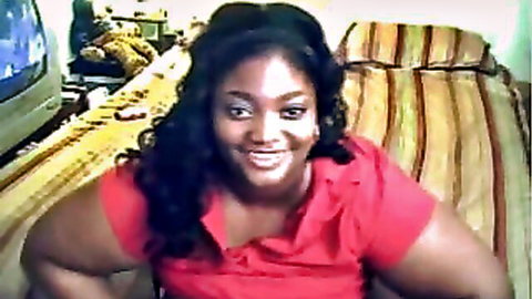 Chubby ebony webcam babe in red top smiling, teasing massive tits