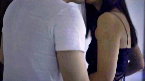 Dane Jones in intimate embrace with man in white tee, black dress, long dark hair
