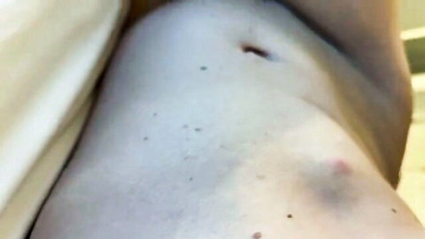 Closeup of pale smooth hip and lower abdomen with piercing hole and freckles