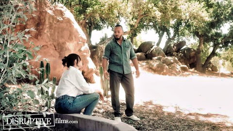 Dakota Payne squatting in jeans with Brandon Anderson outdoors