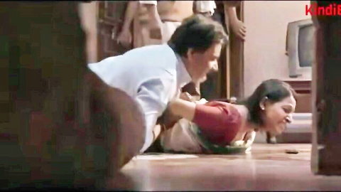 Old man roughly gropes busty Indian wife in red saree on floor during intense scene