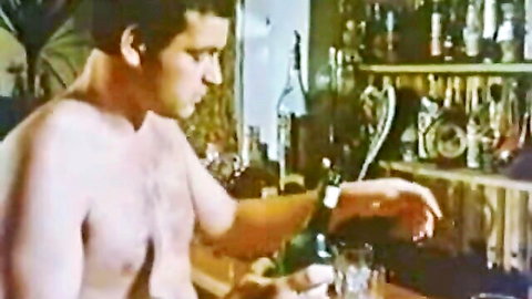 Vintage shirtless man pouring drink in retro bar scene from adult film