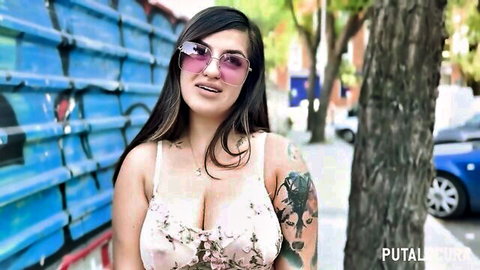 Latina Linda Flor teasing cleavage in low-cut top, tattoos visible outdoors