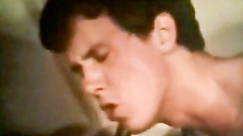 Closeup of young brunette guy's ecstatic face with open mouth moaning in vintage blowjob pleasure