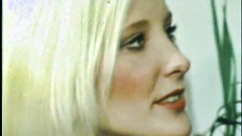 Vintage closeup of sexy blonde babe smiling seductively with red lips and blue eyes