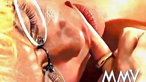 Blonde mature woman with glasses seductively sucks and licks finger with tongue out