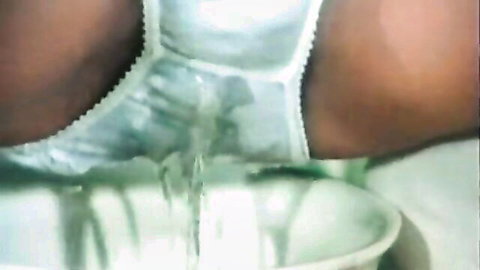 Retro 8mm clip: dark-skinned teen in wet white lingerie with machine fluid drip