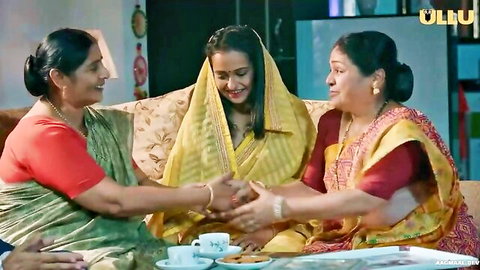 Three Indian women in colorful sarees sharing tea intimately