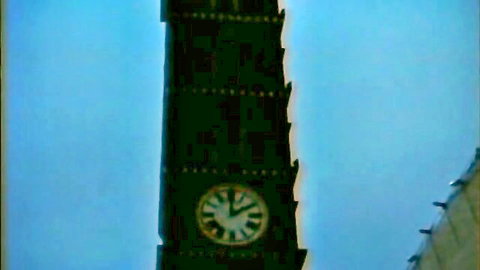Tall clock tower with white clock face against blue sky