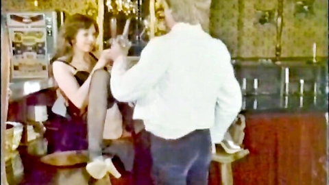 Busty German brunette in dress and stockings with man in intimate bar encounter