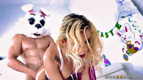 Skinny blonde with small tits exposes perky nipples as muscular Easter bunny masked stud gropes her from behind