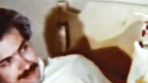 Vintage hairy senior cuddling teddy bear in intimate bedroom scene