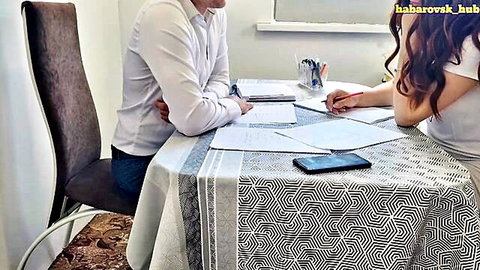 Redhead student in white blouse at office table with man, interview scene