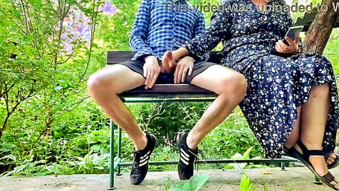 Man exposes big hard cock on public park bench next to woman in floral dress