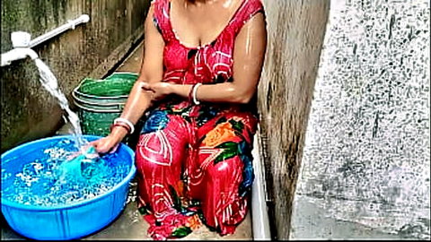 Desi wife in wet red floral dress washing clothes outdoors on balcony