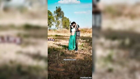 Indian babe in green saree embraces man outdoors in sunny field