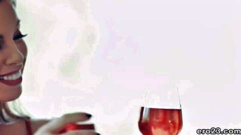 Seductive blonde with big tits smiling while holding red wine glass teasing cleavage