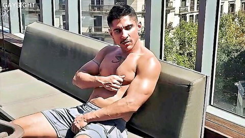 Muscular bearded man shirtless in gray shorts, teasing big cock for summer domination blowjob