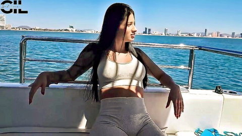 Hot tattooed Latina in sports bra and leggings on yacht, seductive pose