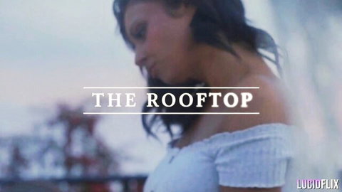 Brunette babe in tight white off-shoulder top posing seductively on rooftop