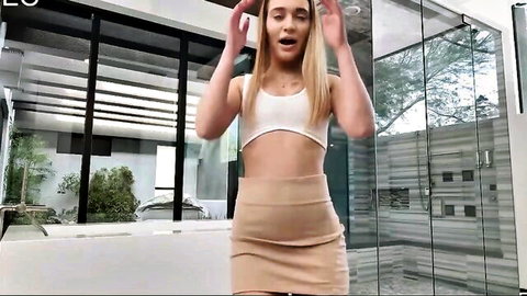 Blonde petite Sera Ryder in white crop top and mini skirt, excited pose