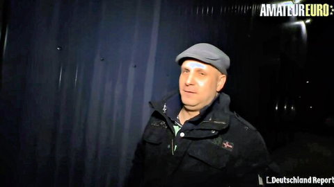 Mature man in gray cap and black jacket standing outdoors in amateur video