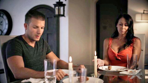 Brunette MILF in low-cut red dress shows deep cleavage at candlelit dinner with handsome guy
