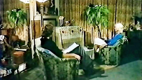 Classy brunette babe sits with older man in vintage porn scene