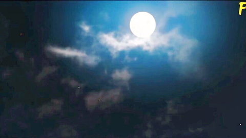 Stunning full moon glowing in dark blue night sky with wispy clouds