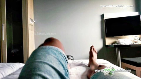 BribedMaid in blue shorts on bed, teasing feet in hotel domination scene