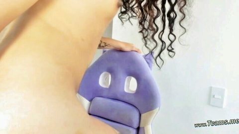Curly haired Latina babe with shoulder tattoo posing nude on purple cat gaming chair
