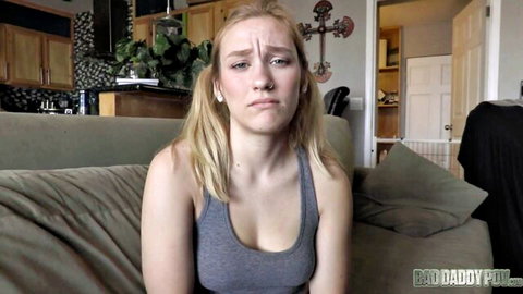 Skinny blonde teen with small tits pouts sadly in tight gray tank top on couch in taboo daddy porn