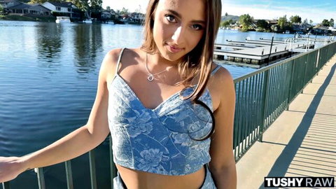 Brunette babe in skimpy blue floral top and tiny denim shorts teases on lakeside dock