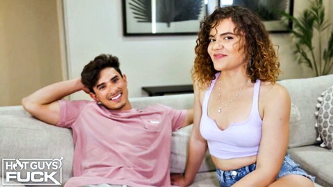 Petite curly brunette with small tits cleavage in crop top and tiny shorts teases with handsome guy on couch