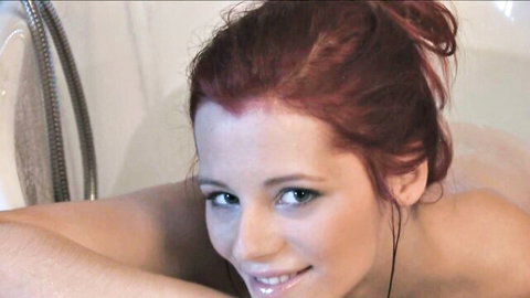 Nude redhead cleaning lady smiling seductively in steamy bathroom