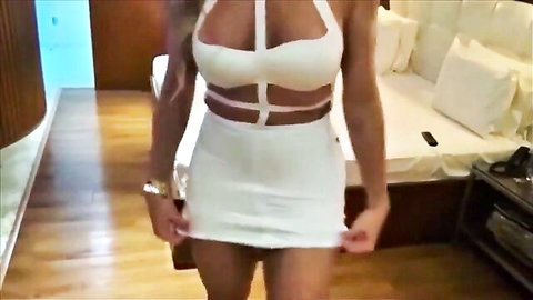 Blonde bombshell in sexy white halter dress, teasing in bedroom