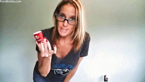 Blonde MILF in glasses holds red cup smirking with deep cleavage tease in dirty talk JOI