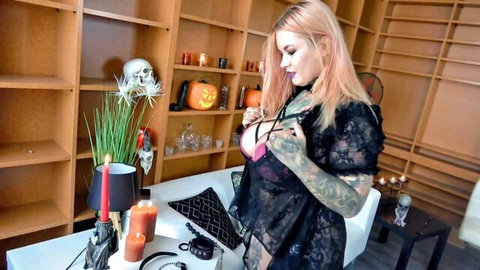 Tattooed fair-skinned pink-haired babe teases ass in sheer black lace lingerie amid Halloween skulls and pumpkins