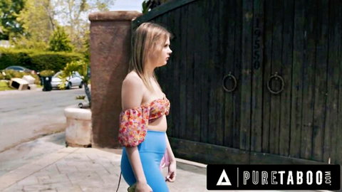 Blonde teen in floral crop top and tight blue leggings teasing her ass by wooden gate