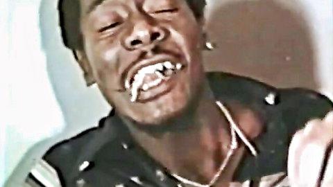 Grinning black stud with gold grills in retro gay porn thumbnail