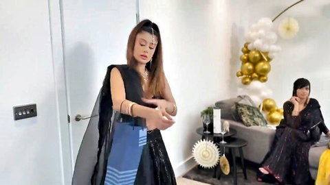 Two curvy olive brunettes in sexy black sarees posing teasingly at balloon party