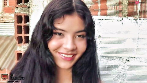 Smiling Asian woman with long dark wavy hair in outdoor photo shoot tease