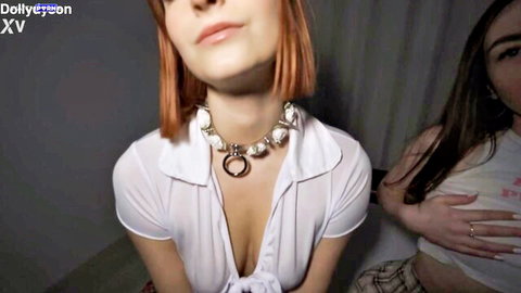 Dolly Dyson in cleavage-revealing white blouse and choker with friend in pink top