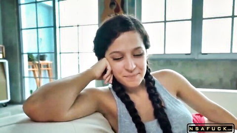 Busty Ariana Marie in gray tank top, relaxed pose on couch