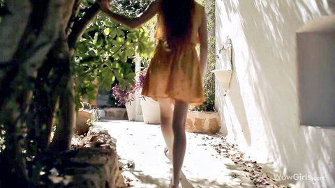 Heidi Romanova walking in short orange dress outdoors