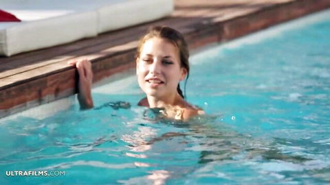 Virginie, stunning brunette babe smiling in Ibiza pool at sunset