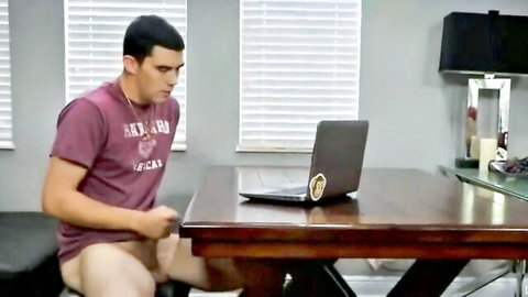 Fit young man exposes cock at desk while using laptop, solo tease