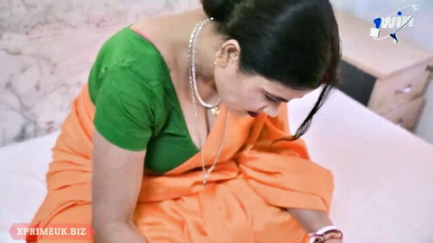 Indian teacher in green blouse and orange saree showing deep cleavage