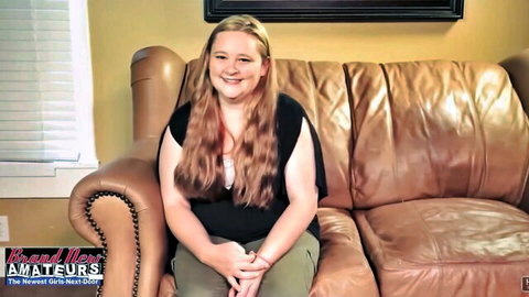 Curvy blonde smiling on couch in casual top, teasing tit-fuck surprise